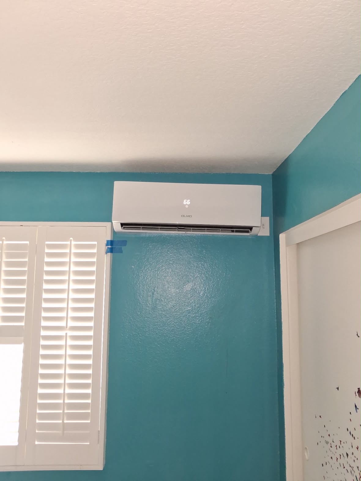 Olmo mini-split head installed in a teal bedroom